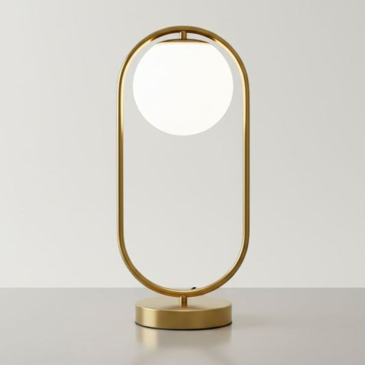 Lampe boule verre laiton éclairée sur table de chevet